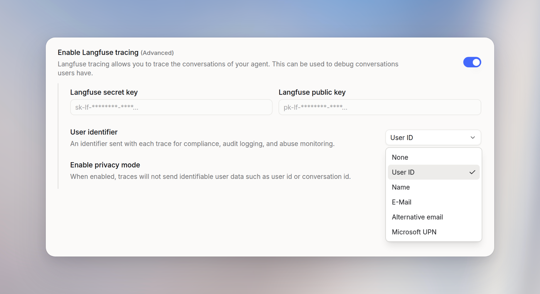 Langfuse tracing panel with tracing enabled, secret key and public key fields, the User identifier menu open on None, User ID, Name, E-Mail, Alternative email, and Microsoft UPN, and Enable privacy mode