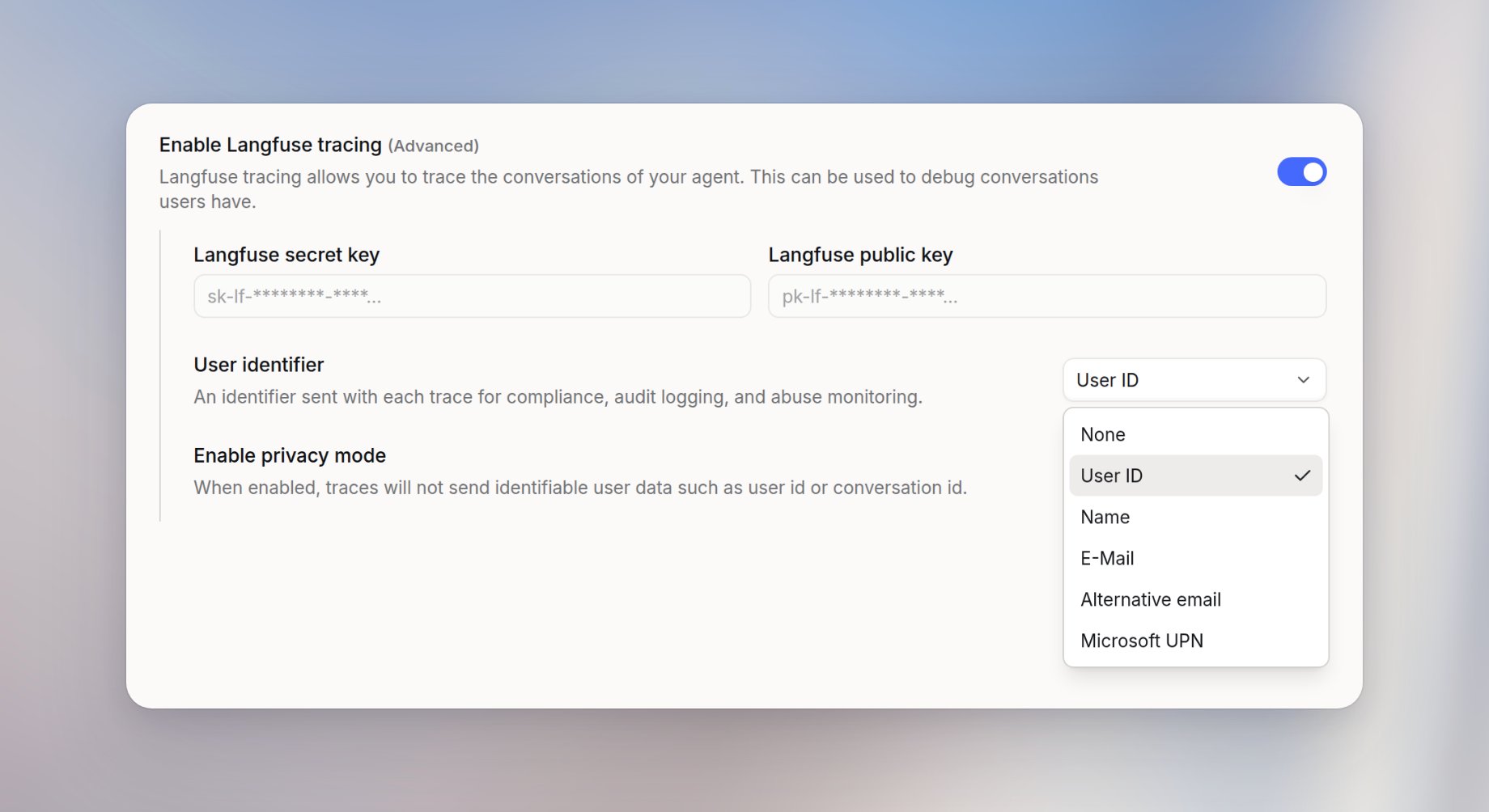 Langfuse tracing panel with tracing enabled, secret key and public key fields, the User identifier menu open on None, User ID, Name, E-Mail, Alternative email, and Microsoft UPN, and Enable privacy mode