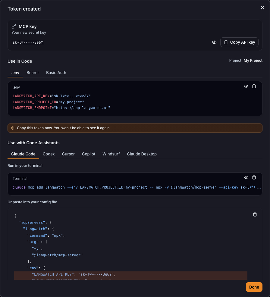 The Token created dialog with the new key, .env values and code assistant snippets