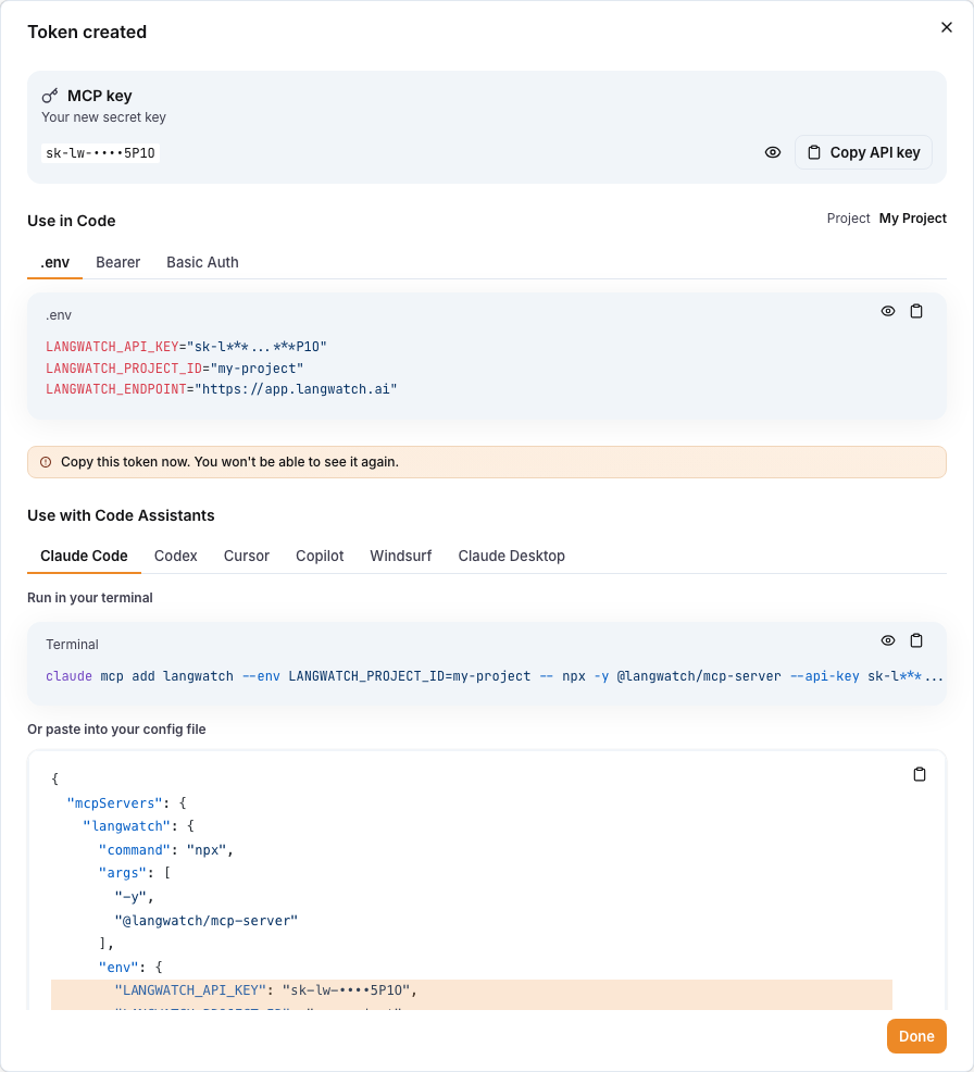 The Token created dialog with the new key, .env values and code assistant snippets