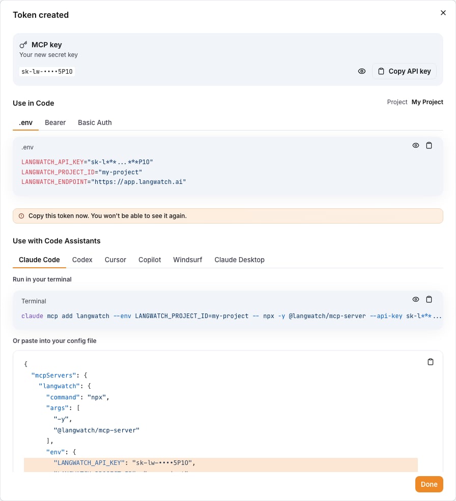 The Token created dialog with the new key, .env values and code assistant snippets