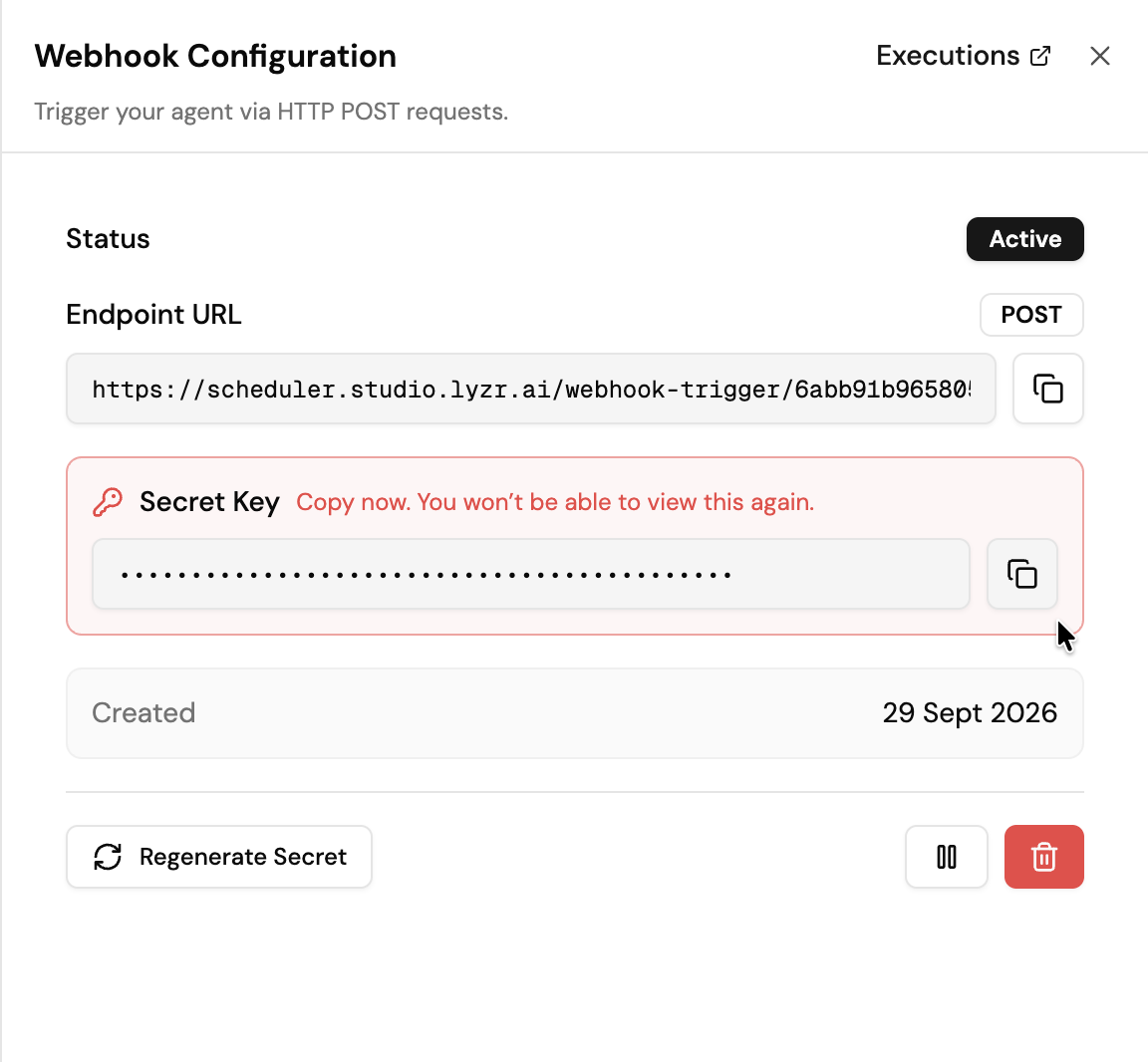 Screenshot of the Webhook Configuration panel, showing Status set to Active, the POST Endpoint URL https://scheduler.studio.lyzr.ai/webhook-trigger/ followed by the webhook ID with a copy button, a masked Secret Key with the warning "Copy now. You won't be able to view this again." and a copy button, the Created date, and Regenerate Secret, Pause, and Delete buttons.