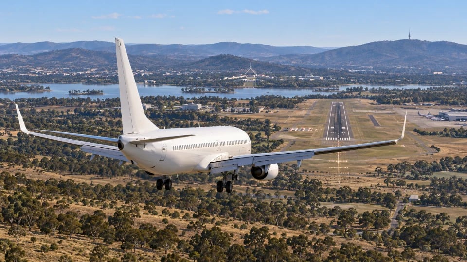 A Boeing 737-800 approaching Canberra with its landing gear down.