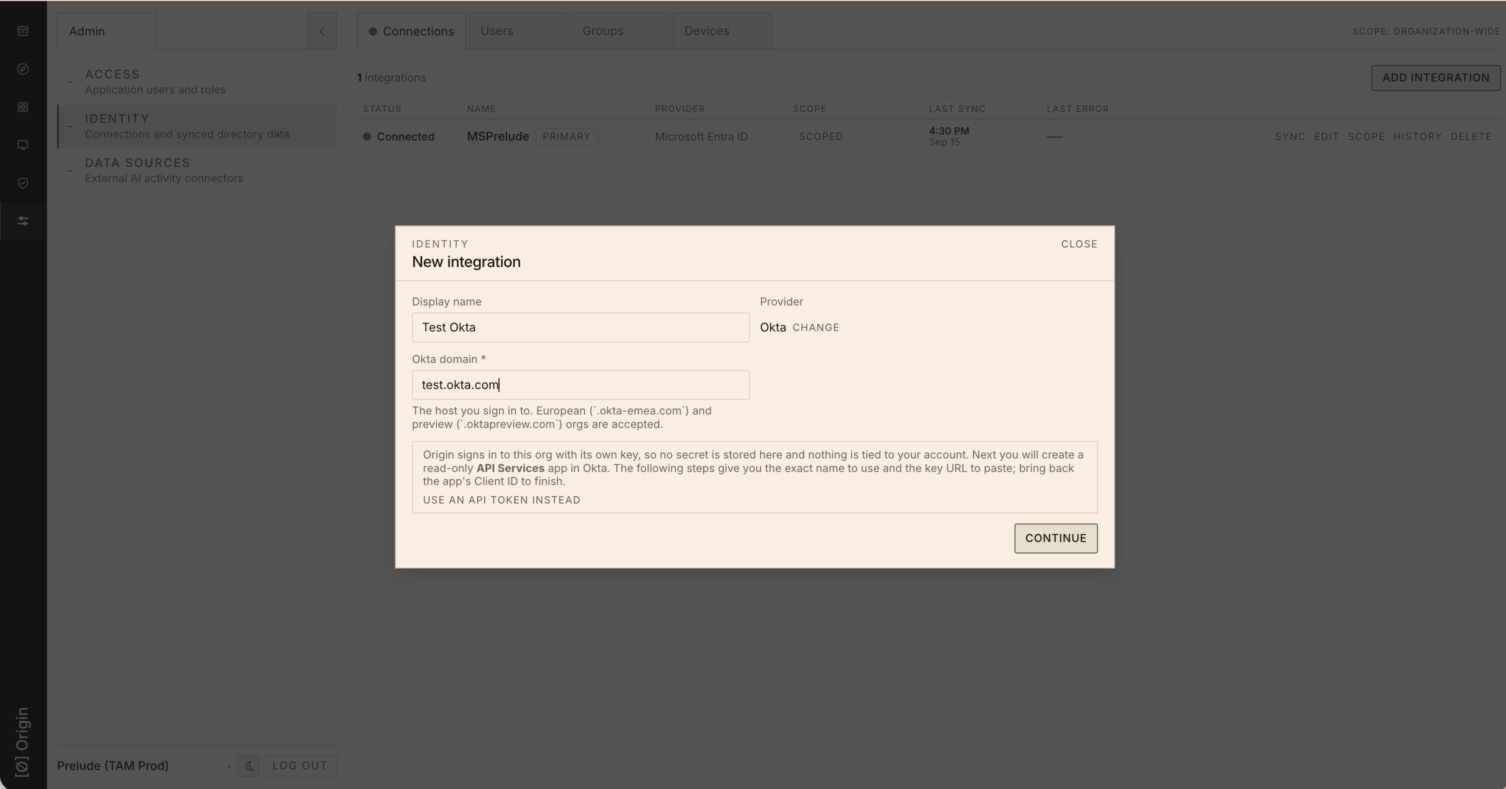 The Origin New integration dialog with Okta selected as the provider and an Okta domain entered, before clicking Continue.