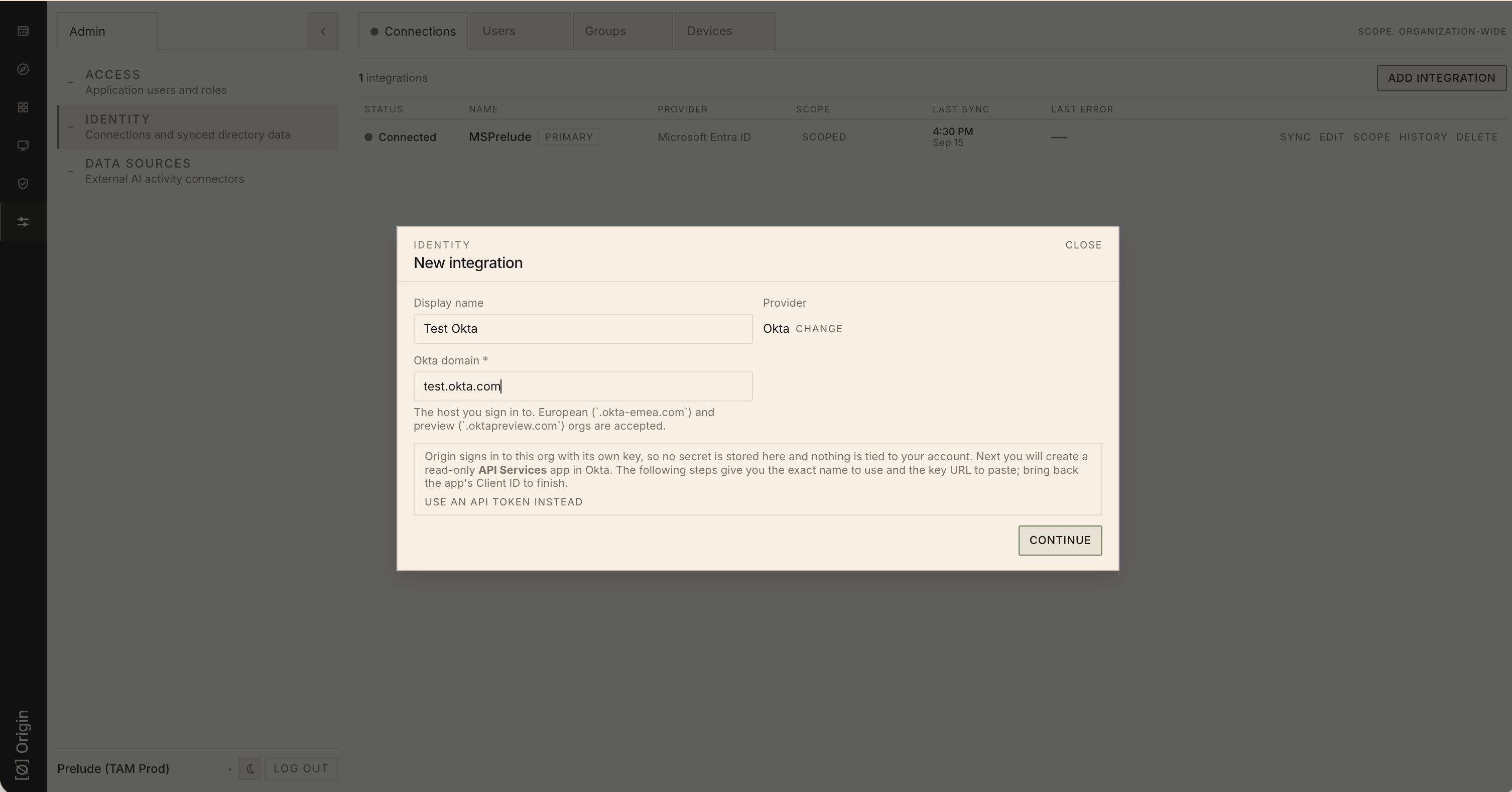 The Origin New integration dialog with Okta selected as the provider and an Okta domain entered, before clicking Continue.