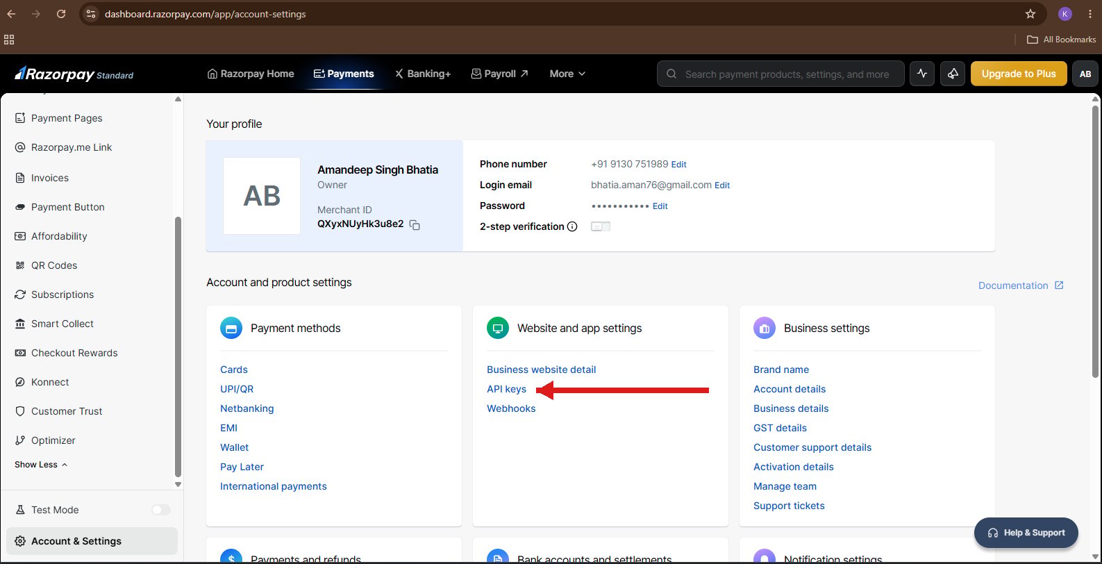 Razorpay Account Settings page with a red arrow pointing to the API keys link under Website and app settings