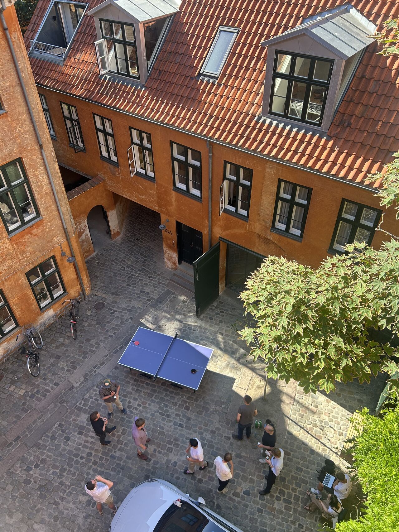 Aerial view of the courtyard with people gathered around a table tennis table.