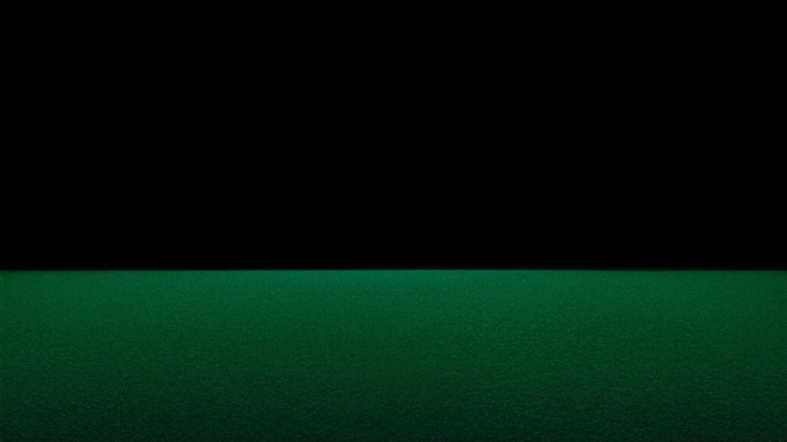 A very wide dark plane under a luminous green horizon line