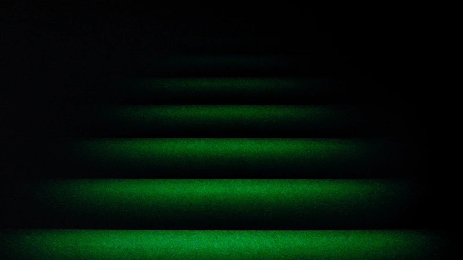 Descending matt steps, the green light weaker on each one