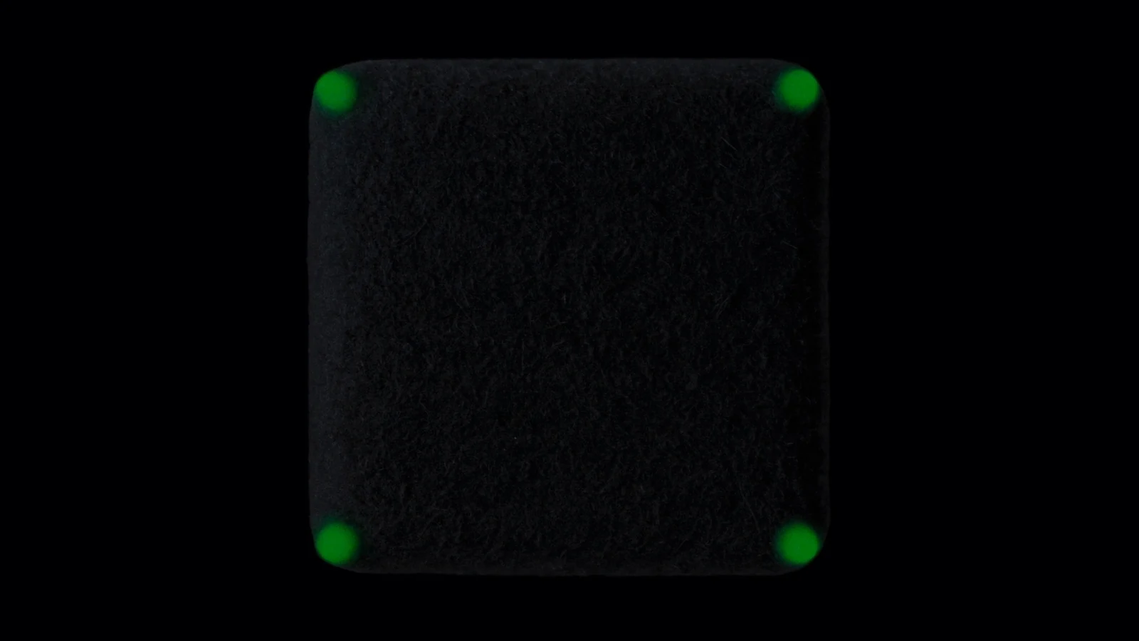 Four green points arranged around a dark matte cube