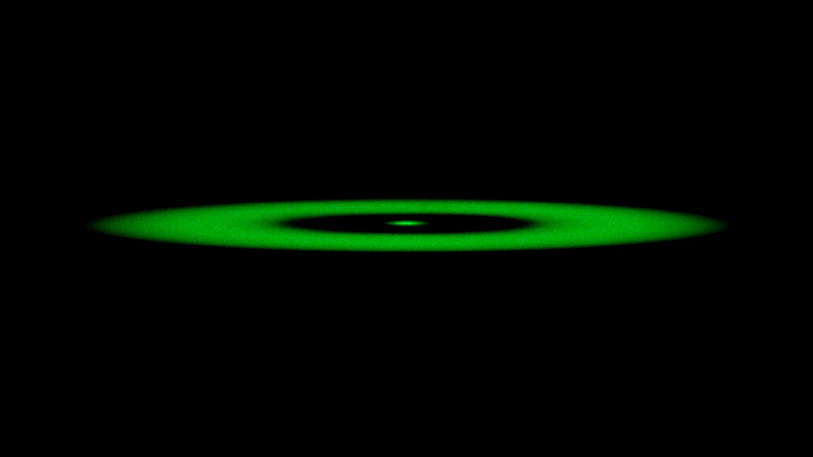 A wide ring of green light lying flat on an almost black background, like a wave sweeping across