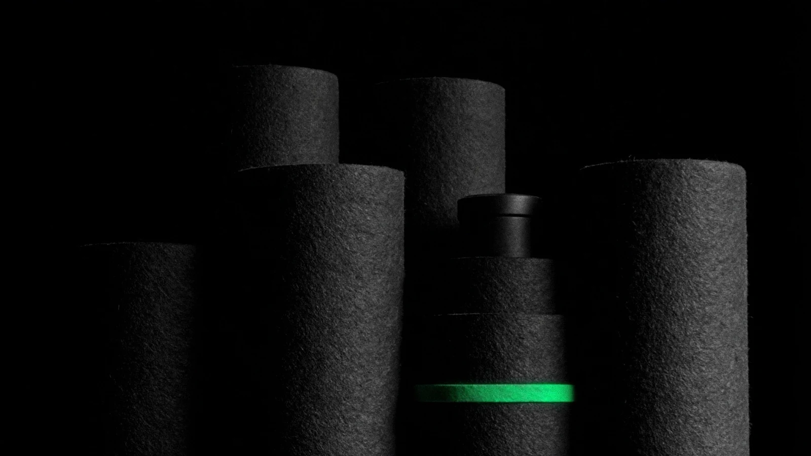 Plusieurs cylindres mats debout, l'un d'eux cerné d'un mince liseré vert