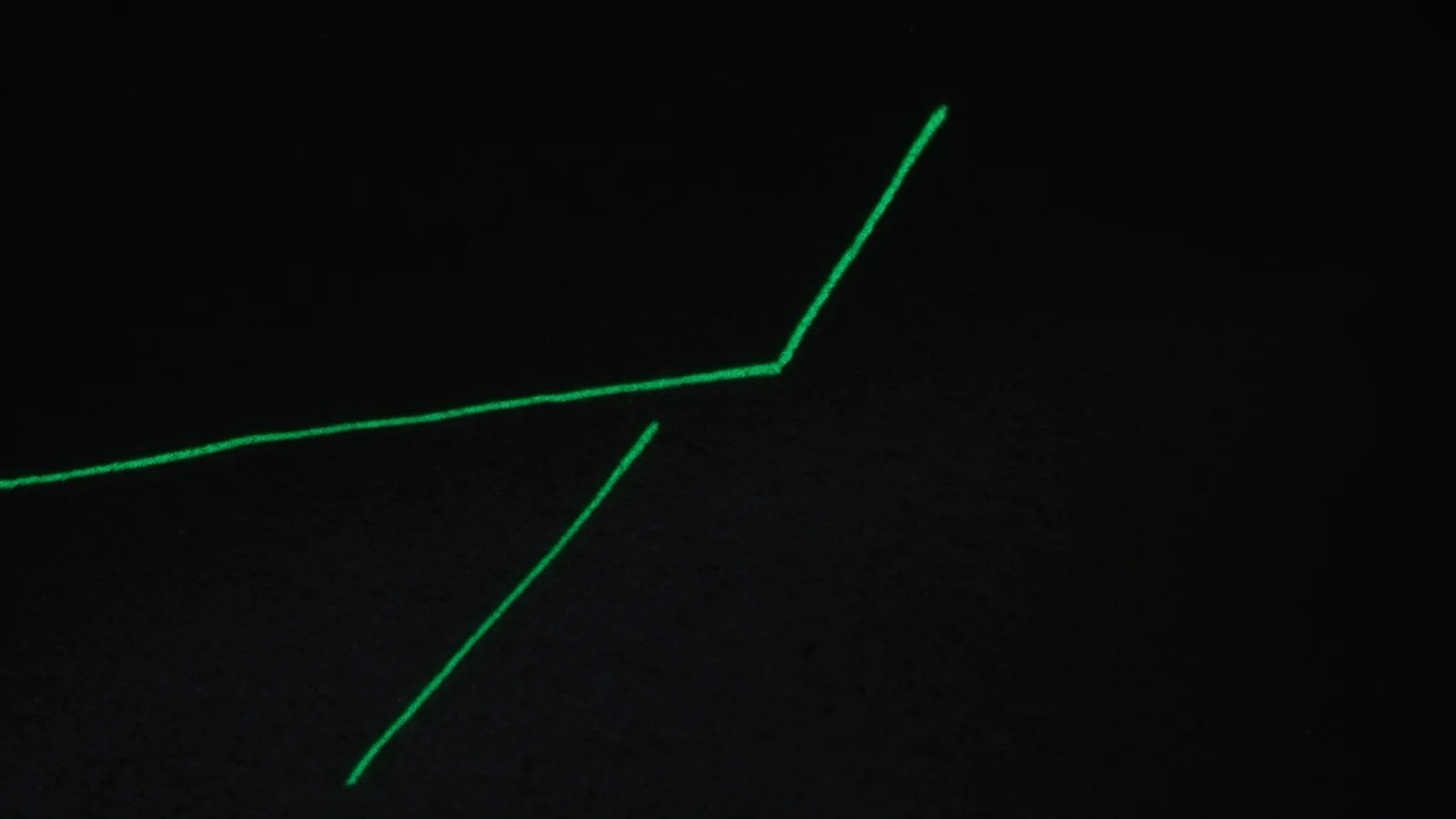 Two parallel green lines converging without meeting, on a near-black background