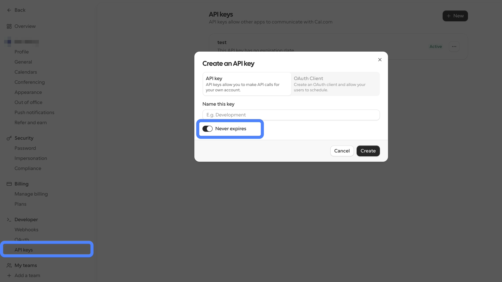 Cal.com settings with API keys highlighted under Developer in the left sidebar. The Create an API key dialog is open on the API key tab, with a Name this key field, the Never expires toggle switched on and highlighted with a blue ring, and Cancel and Create buttons. Behind the dialog, an existing key named test shows as Active with no expiration date.