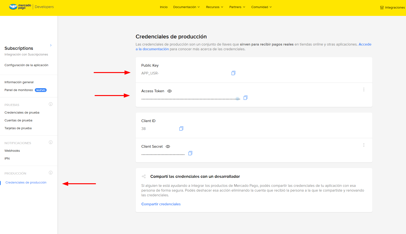 Pantalla de credenciales de producción de Mercado Pago. Flechas rojas señalan tres puntos: en el menú lateral, la opción «Credenciales de producción» dentro de la sección PRODUCCIÓN; y en el panel, los campos Public Key y Access Token, que son los dos valores a copiar. Más abajo se ven Client ID y Client Secret, que no se usan.