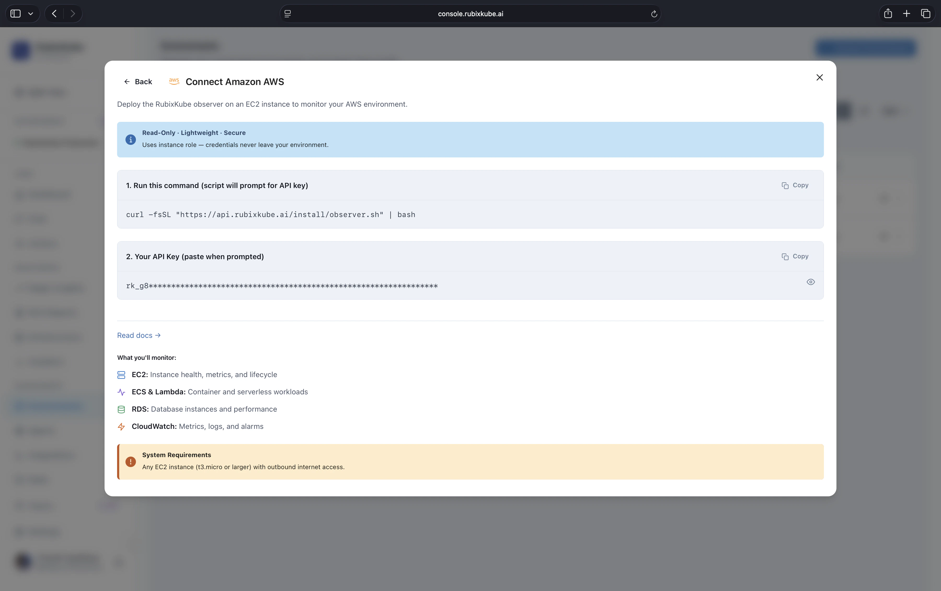 Connect Amazon AWS dialog with a one-line installer command, the API key input, the list of what will be monitored (EC2, ECS and Lambda, RDS, CloudWatch), and a system requirements callout.