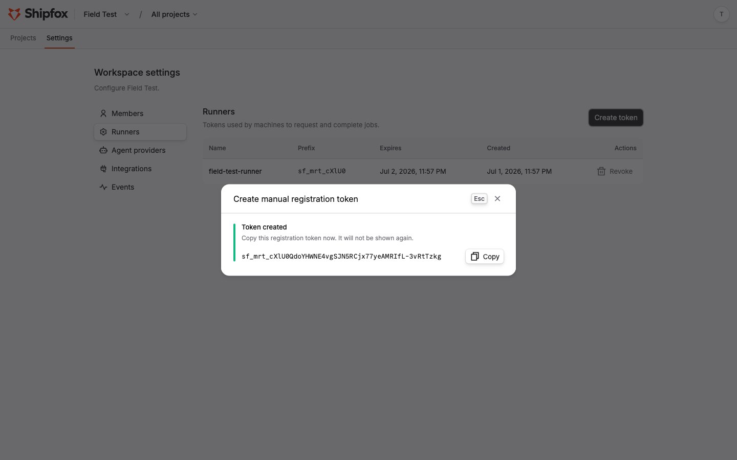 The create registration token dialog on Settings → Runners, showing the one-time token value and copy button
