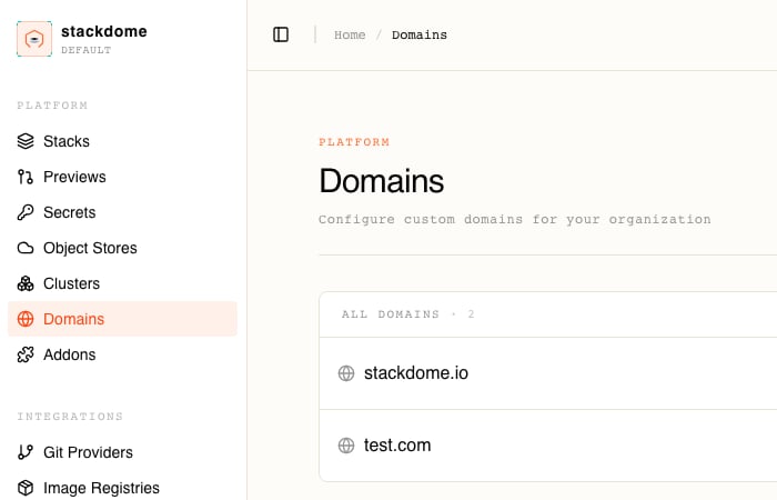 The Domains page in the Stackdome dashboard, with Domains highlighted under PLATFORM in the sidebar and the page headed PLATFORM Domains above the subtitle Configure custom domains for your organization, and an ALL DOMAINS panel counting 2 rows — stackdome.io and test.com — each with a globe icon