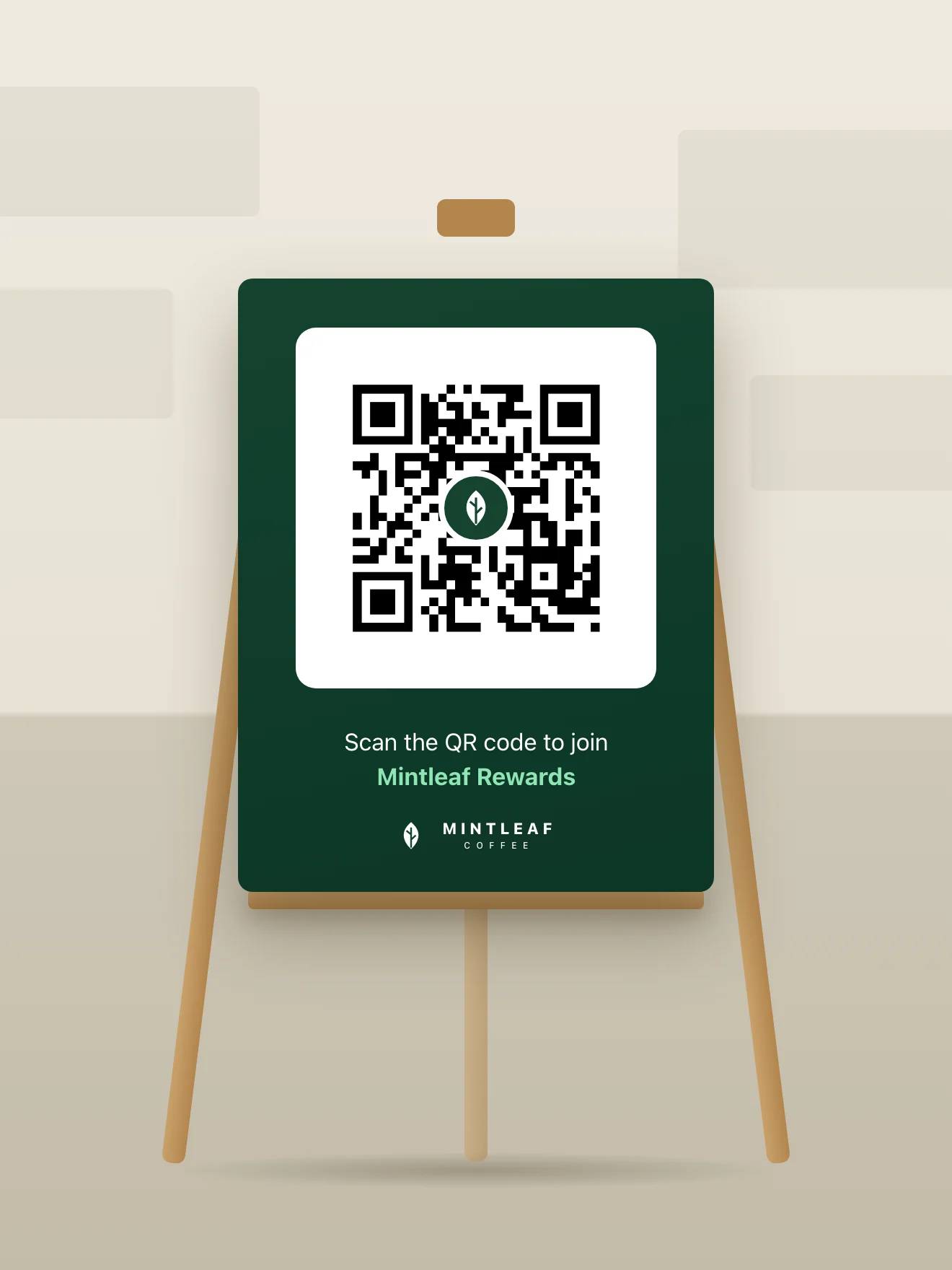 A Mintleaf Rewards floor easel in a store walkway, holding a dark green board with a giant QR code and the line Scan the QR code to join Mintleaf Rewards