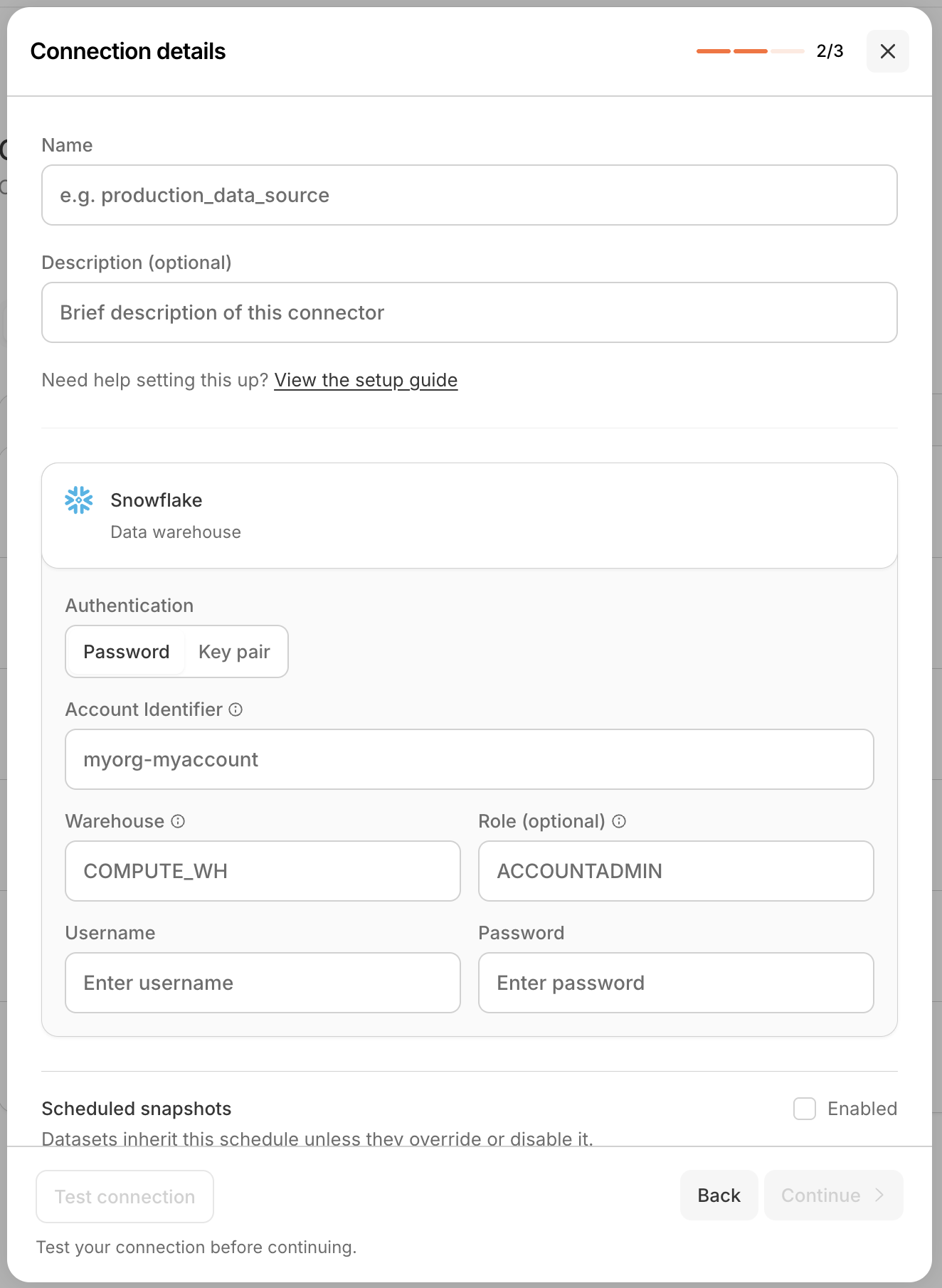 Step 2 of 3 of the wizard, titled 'Connection details' (2/3). It has Name and optional Description fields, a 'Need help setting this up? View the setup guide' link, and a Snowflake section with an Authentication toggle between Password and Key pair, plus Account Identifier (myorg-myaccount), Warehouse (COMPUTE_WH), optional Role (ACCOUNTADMIN), Username, and Password fields. Below is a 'Scheduled snapshots' row with an Enabled checkbox and the note 'Datasets inherit this schedule unless they override or disable it.', and Test connection, Back, and Continue buttons with the hint 'Test your connection before continuing.'