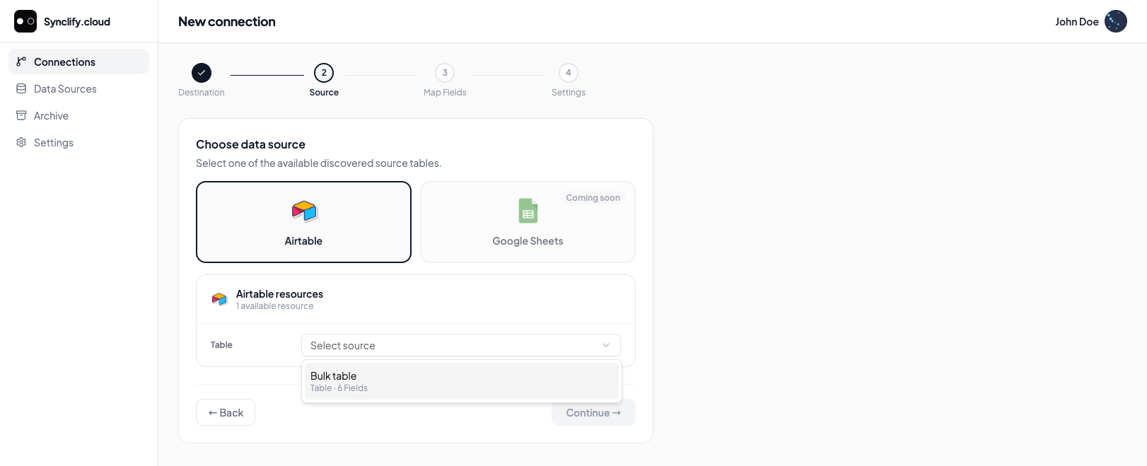 Wizard step 2: Airtable selected as the source with a table dropdown; Google Sheets shown as Coming soon