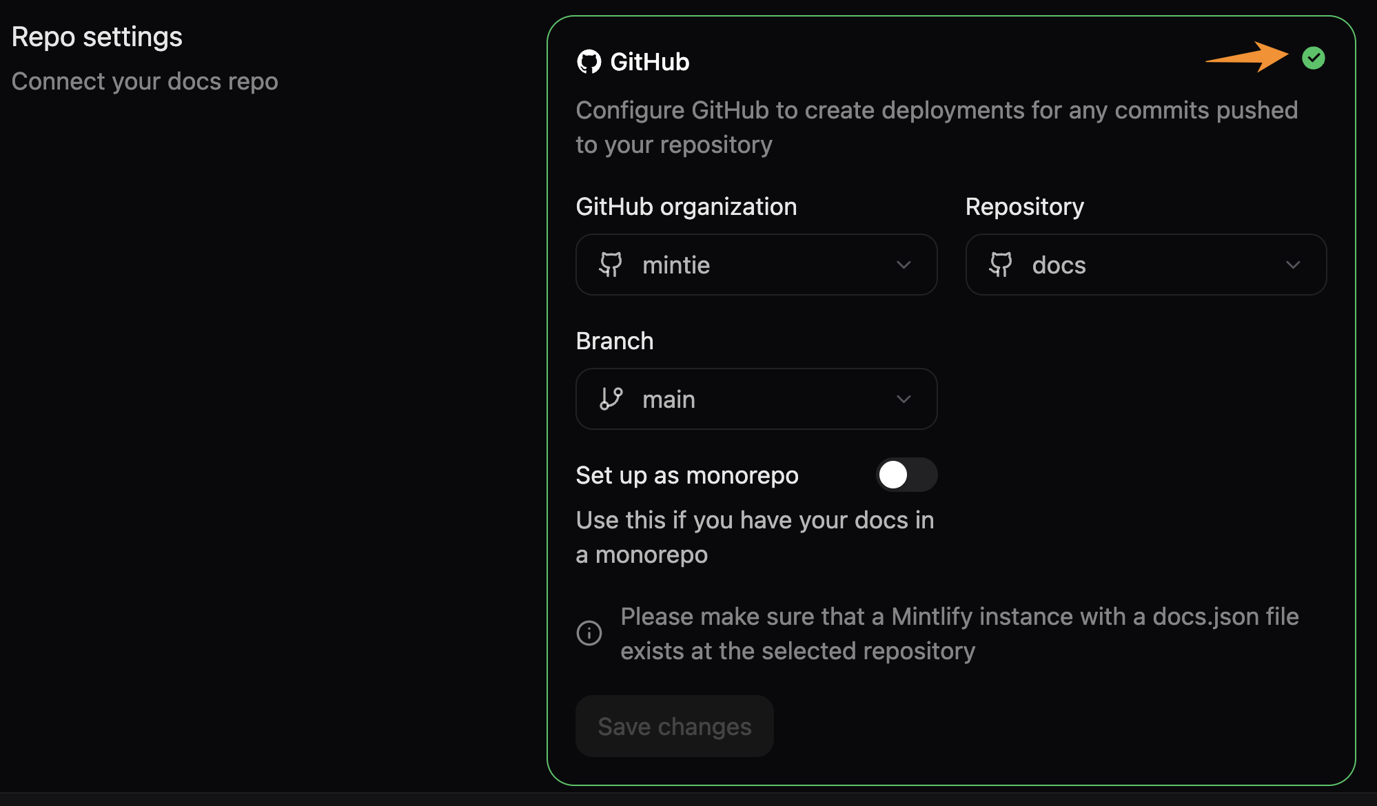 Mintlify 控制台中的 Git Settings 页面。橙色箭头指向用于重新验证存储库设置的绿色勾选图标。