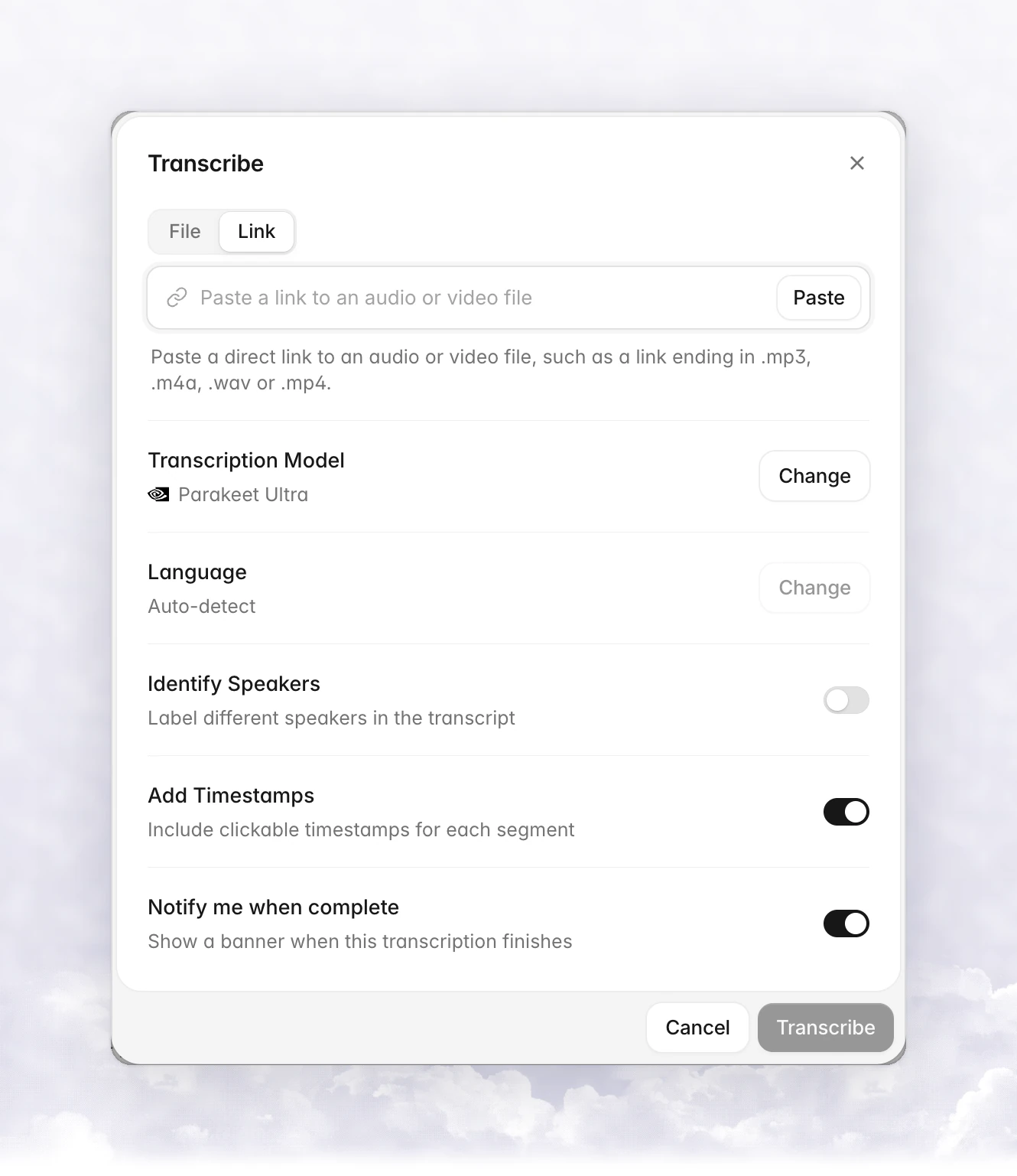 The Transcribe dialog on the Link tab with a Paste a link to an audio or video file field, a Paste button, and the Transcription Model, Language, Identify Speakers, Add Timestamps and Notify me when complete rows