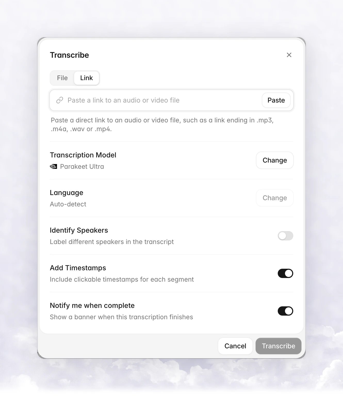 The Transcribe dialog on the Link tab with a Paste a link to an audio or video file field, a Paste button, and the Transcription Model, Language, Identify Speakers, Add Timestamps and Notify me when complete rows