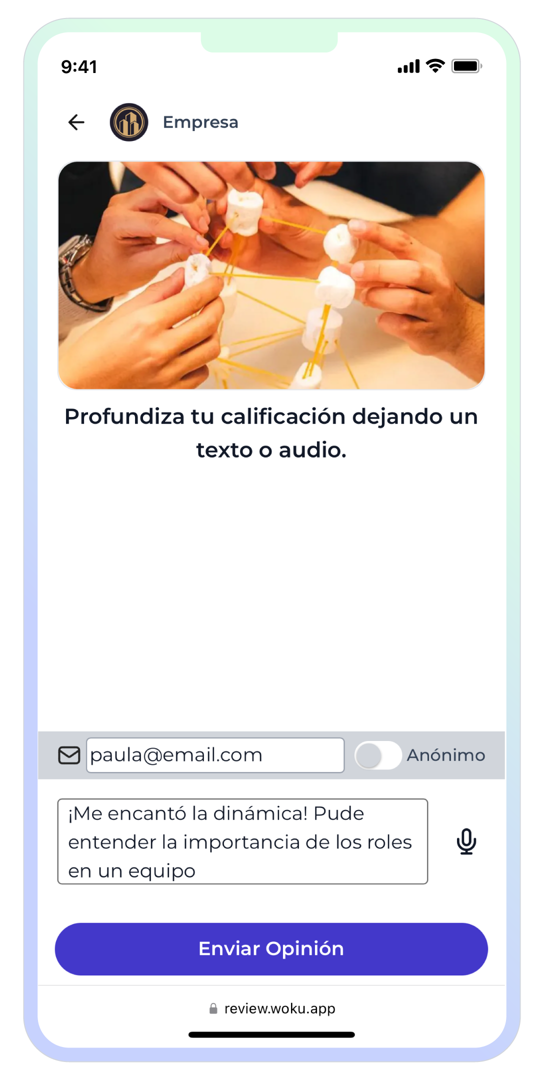 Interfaz de woku en un dispositivo móvil, donde en la parte superior se muestra el logo de la empresa junto con su nombre ('Empresa'). Debajo, aparece la imagen representativa del 'Taller de Trabajo en Equipo'. Luego, se ofrece la opción de dejar una opinión en formato de texto o audio. En este caso, la persona eligió dejar una reseña en texto, escribiendo '¡Me encantó la dinámica! Pude entender la importancia de los roles en un equipo'. También está la opción de ingresar un correo electrónico o marcar la reseña como anónima antes de enviarla.